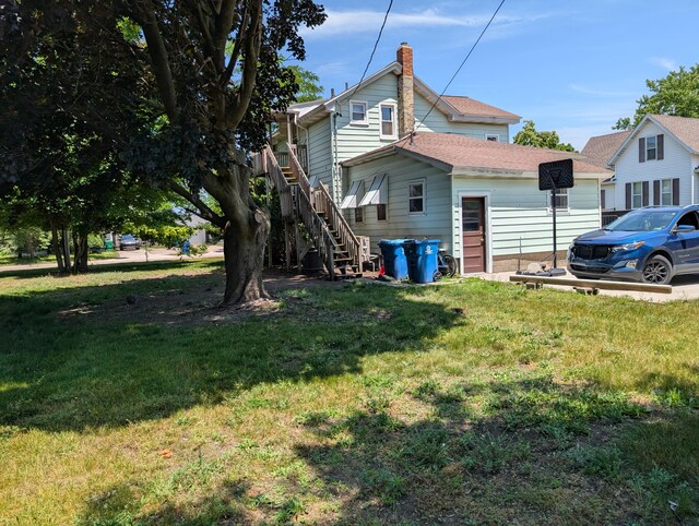 1236 Fulton Ave, Grand Haven, MI 49417 - view of home's exterior with a yard and stairs