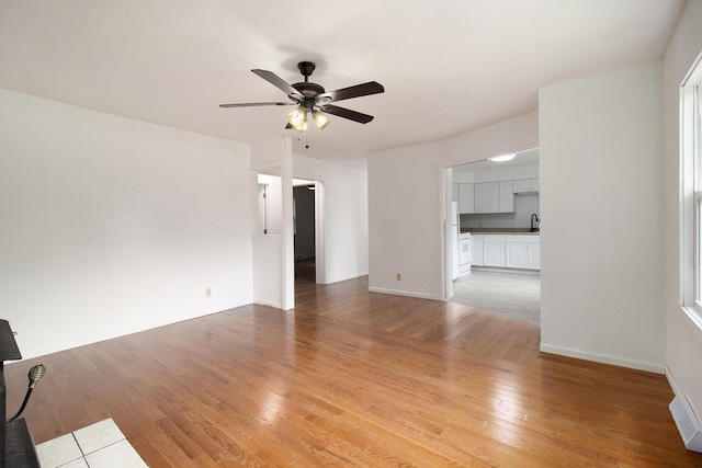 105 S Emerson Lake Rd, Branch, MI 49402 - unfurnished living room with a ceiling fan and light wood-style floors