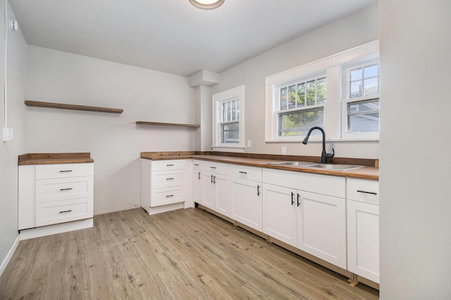 11 S Broad St, Battle Creek, MI 49017 - kitchen with open shelves, light wood-style floors, white cabinetry, and butcher block countertops