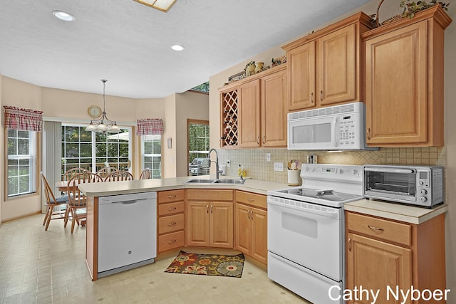4232 Limousin Ct SW, Grandville, MI 49418 - kitchen featuring white appliances, light flooring, a peninsula, decorative backsplash, and light countertops