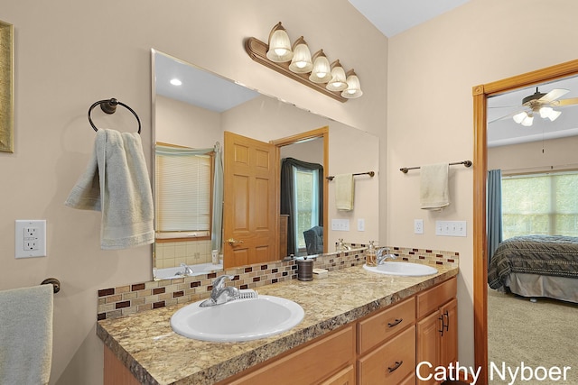 4232 Limousin Ct SW, Grandville, MI 49418 - bathroom featuring connected bathroom, decorative backsplash, double vanity, and a ceiling fan