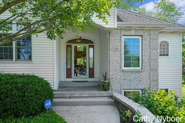 4232 Limousin Ct SW, Grandville, MI 49418 - property entrance featuring a shingled roof and brick siding