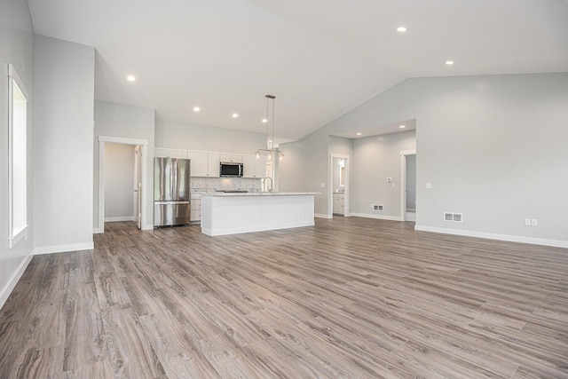 57860 James Dr, Three Rivers, MI 49093 - unfurnished living room featuring lofted ceiling, light wood-type flooring, and recessed lighting