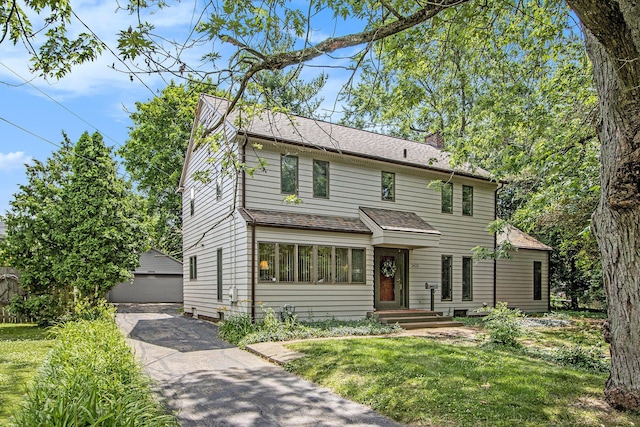2425 University Ave, Kalamazoo, MI 49008 - traditional-style house featuring a detached garage, an outbuilding, a front lawn, a chimney, and a shingled roof