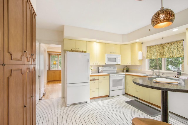 2425 University Ave, Kalamazoo, MI 49008 - kitchen with white appliances, light floors, cream cabinetry, recessed lighting, and decorative light fixtures