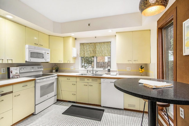 2425 University Ave, Kalamazoo, MI 49008 - kitchen featuring white appliances, cream cabinets, light flooring, decorative backsplash, and light countertops