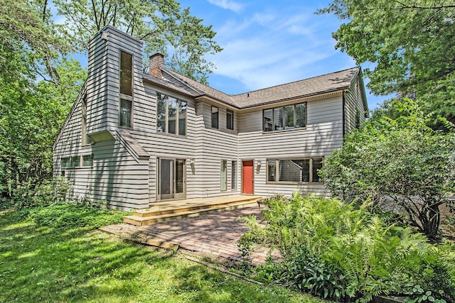 2425 University Ave, Kalamazoo, MI 49008 - rear view of house with a chimney, a patio area, a lawn, and a wooden deck