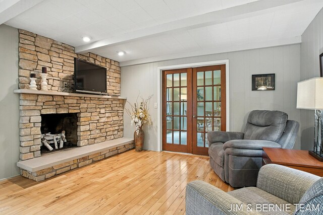 8518 146th Ave, West Olive, MI 49460 - living area with french doors, hardwood / wood-style flooring, beam ceiling, and a stone fireplace