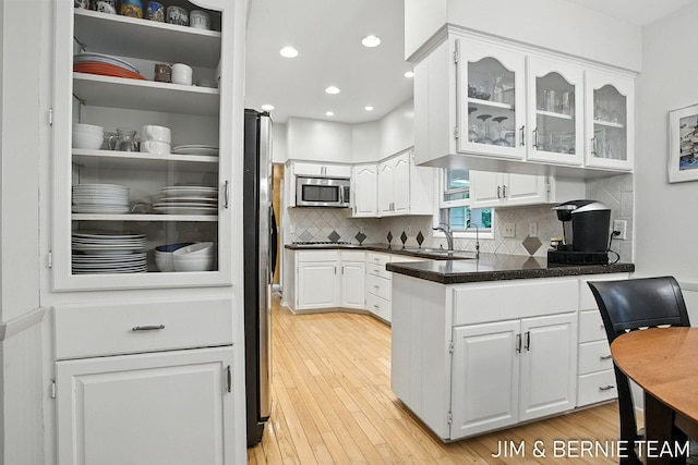 8518 146th Ave, West Olive, MI 49460 - kitchen with appliances with stainless steel finishes, white cabinetry, glass insert cabinets, backsplash, and recessed lighting