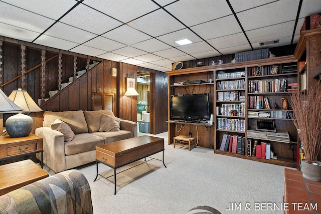 8518 146th Ave, West Olive, MI 49460 - living room featuring stairway, wooden walls, a drop ceiling, and carpet