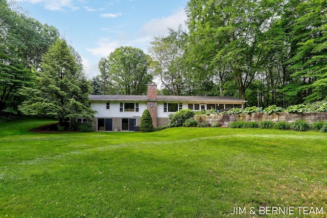 8518 146th Ave, West Olive, MI 49460 - view of front of home featuring a chimney, a front lawn, and brick siding