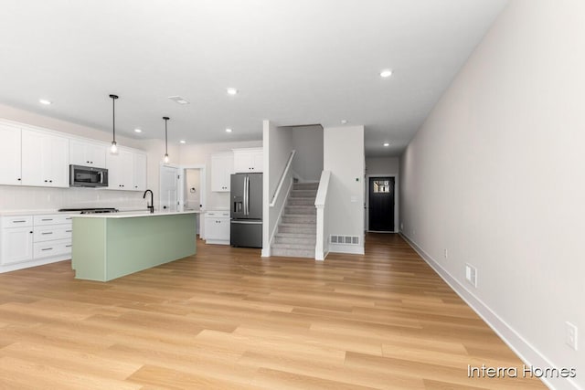 3345 Kings River St SW Unit 38, Wyoming, MI 49418 - kitchen with stainless steel appliances, white cabinetry, a center island with sink, recessed lighting, and light wood finished floors