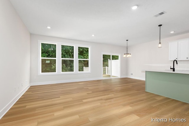 3345 Kings River St SW Unit 38, Wyoming, MI 49418 - unfurnished living room featuring a chandelier, light wood-style floors, recessed lighting, and radiator