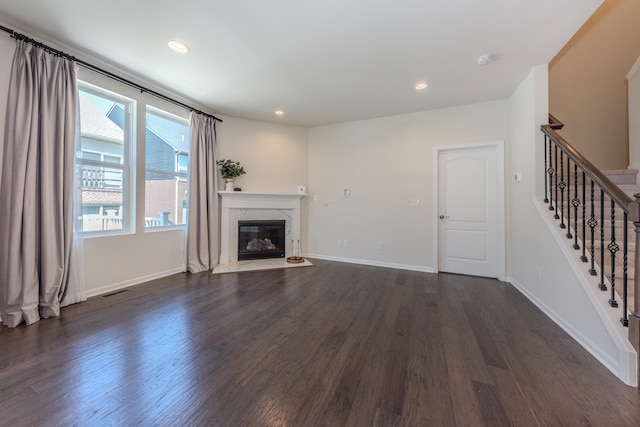 2763 Polson St, Ann Arbor, MI 48105 - unfurnished living room featuring dark wood-type flooring, stairway, a premium fireplace, and recessed lighting
