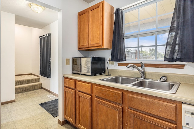 885 Broadway, Benton Harbor, MI 49022 - kitchen featuring light countertops, brown cabinets, dishwasher, and light flooring
