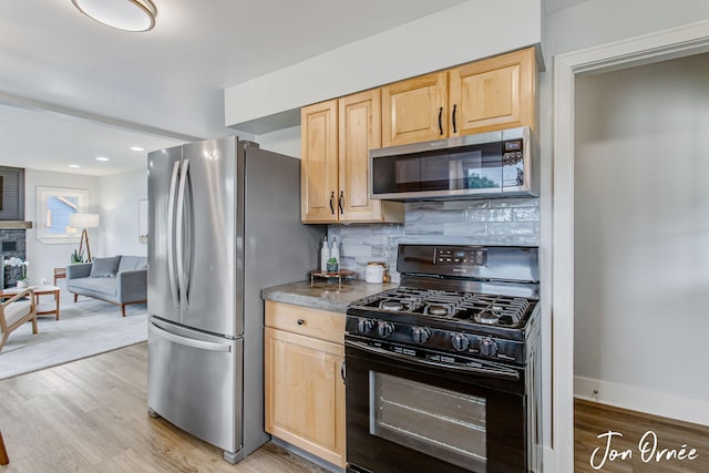 6116 Eastern Ave SE, Grand Rapids, MI 49508 - kitchen with stainless steel appliances, light brown cabinets, decorative backsplash, light wood-style floors, and open floor plan