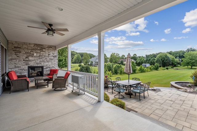 46140 Finch St, Mattawan, MI 49071 - view of patio / terrace featuring ceiling fan, outdoor dining space, an outdoor living space with a fireplace, and view of wooded area