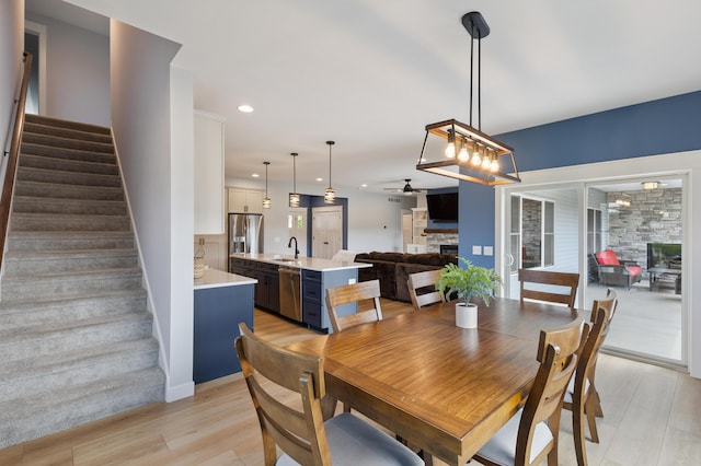 46140 Finch St, Mattawan, MI 49071 - dining room featuring a stone fireplace, stairs, ceiling fan, light wood-type flooring, and recessed lighting