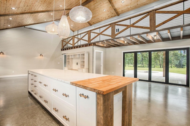 17756 Brad Ln, Three Rivers, MI 49093 - kitchen featuring high vaulted ceiling, concrete floors, a wood ceiling with exposed beams, white cabinetry, and decorative light fixtures