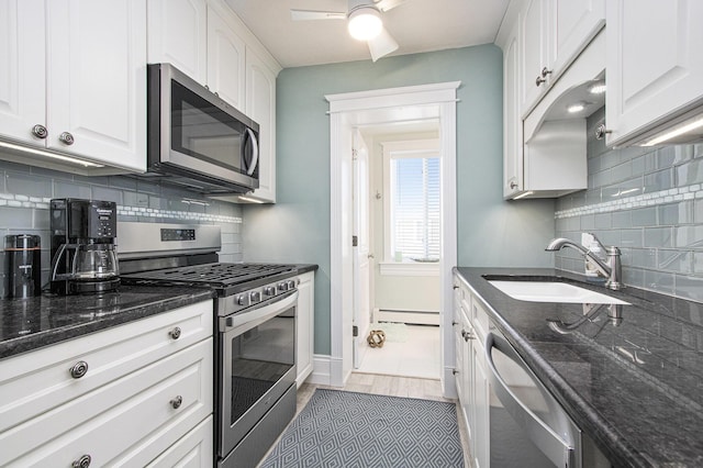 225 N Shore Dr Unit 302, South Haven, MI 49090 - kitchen featuring stainless steel appliances, baseboard heating, decorative backsplash, a ceiling fan, and white cabinets