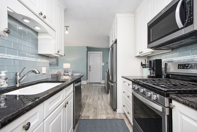 225 N Shore Dr Unit 302, South Haven, MI 49090 - kitchen with stainless steel appliances, backsplash, white cabinets, light wood-type flooring, and dark stone countertops