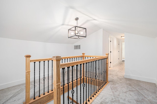 802 Clinton St, Marshall, MI 49068 - hall with an upstairs landing, light carpet, vaulted ceiling, and a chandelier