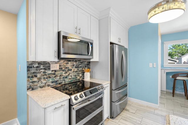 510 Wayne St, Saint Joseph, MI 49085 - kitchen featuring stainless steel appliances, backsplash, white cabinetry, and light stone counters