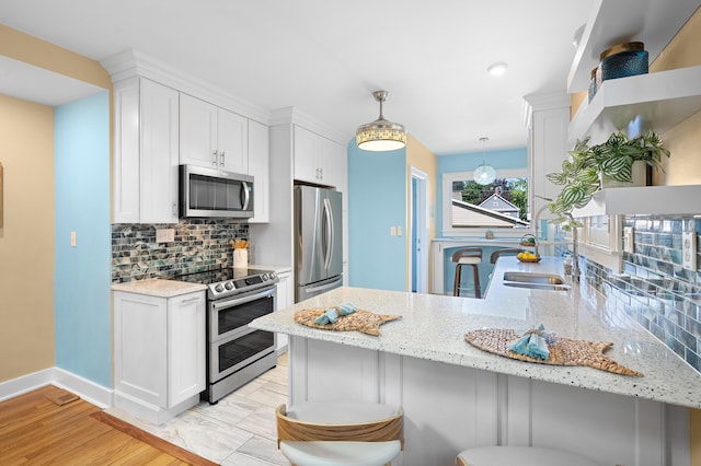 510 Wayne St, Saint Joseph, MI 49085 - kitchen with appliances with stainless steel finishes, a peninsula, white cabinetry, and tasteful backsplash