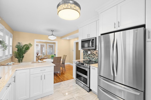 510 Wayne St, Saint Joseph, MI 49085 - kitchen featuring appliances with stainless steel finishes, white cabinets, backsplash, light stone counters, and light marble finish flooring