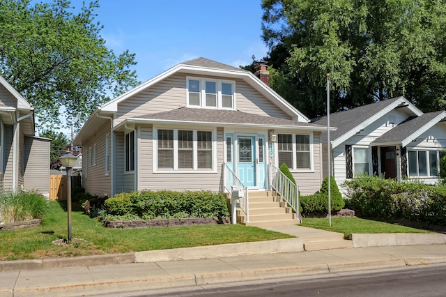 510 Wayne St, Saint Joseph, MI 49085 - bungalow-style home with a chimney, a front lawn, entry steps, and roof with shingles
