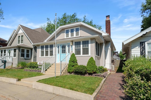 510 Wayne St, Saint Joseph, MI 49085 - bungalow with a front lawn, a chimney, and entry steps