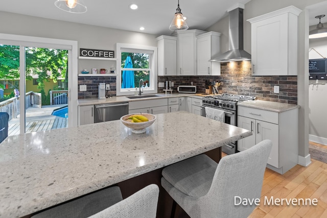 2845 Ridgecrest St SW, Byron Center, MI 49315 - kitchen featuring wall chimney range hood, appliances with stainless steel finishes, plenty of natural light, a kitchen breakfast bar, and recessed lighting