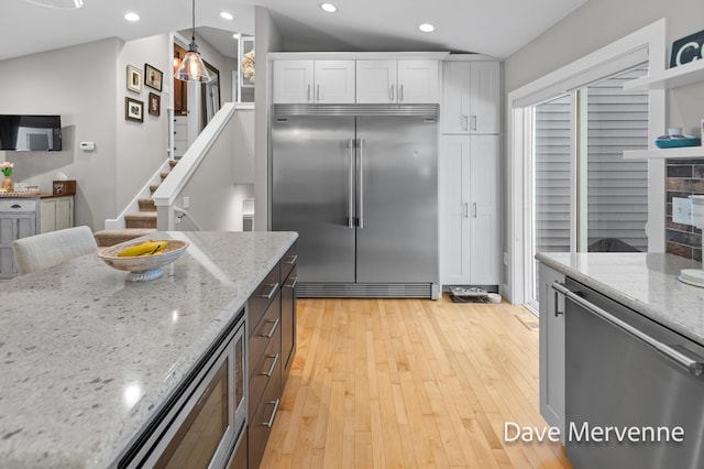 2845 Ridgecrest St SW, Byron Center, MI 49315 - kitchen with built in fridge, white cabinets, recessed lighting, light stone counters, and light wood finished floors