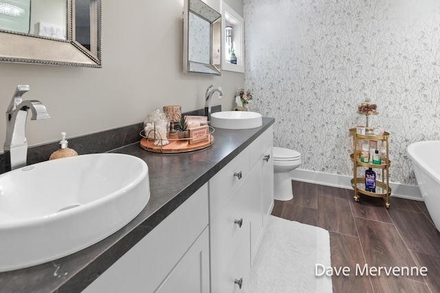 2845 Ridgecrest St SW, Byron Center, MI 49315 - full bath with a freestanding bath, double vanity, wallpapered walls, and wood finished floors