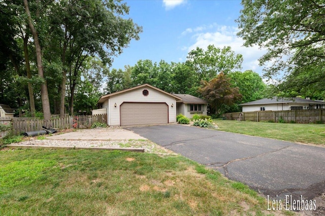 4712 Shank St NE, Rockford, MI 49341 - ranch-style home with an attached garage, asphalt driveway, and view of wooded area