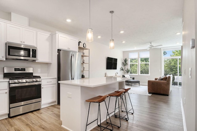 2319 Watertown Way, Grand Rapids, MI 49505 - kitchen with appliances with stainless steel finishes, open floor plan, light wood finished floors, recessed lighting, and light countertops