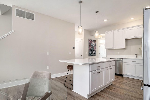 2319 Watertown Way, Grand Rapids, MI 49505 - kitchen featuring dishwasher, a center island, white cabinetry, light countertops, and wood finished floors