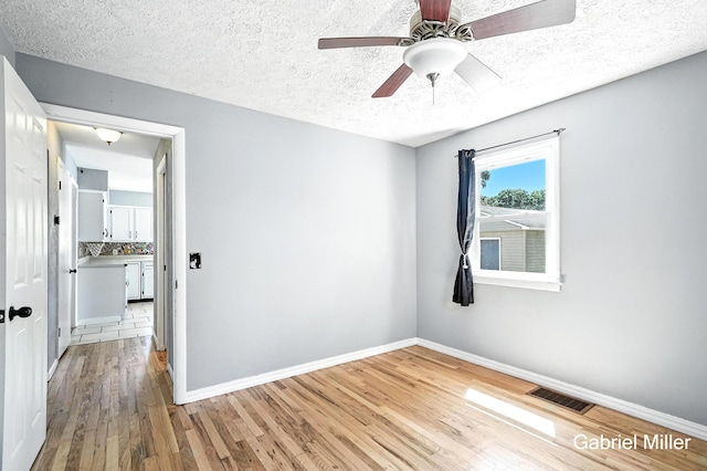 3725 Colby Ave SW, Wyoming, MI 49509 - empty room with wood finished floors, a textured ceiling, and a ceiling fan