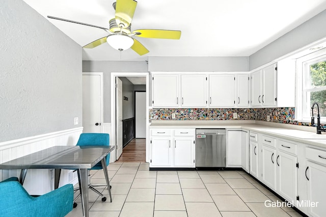 3725 Colby Ave SW, Wyoming, MI 49509 - kitchen with stainless steel dishwasher, a textured wall, a ceiling fan, white cabinetry, and a wainscoted wall