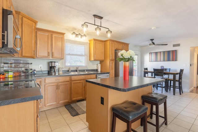 1762 Smyers Dr, Benton Harbor, MI 49022 - kitchen with stainless steel appliances, light tile patterned floors, dark countertops, and a kitchen island