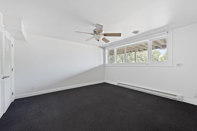 48002 Ridge Rd, New Buffalo, MI 49117 - spare room with baseboard heating, dark carpet, and a ceiling fan