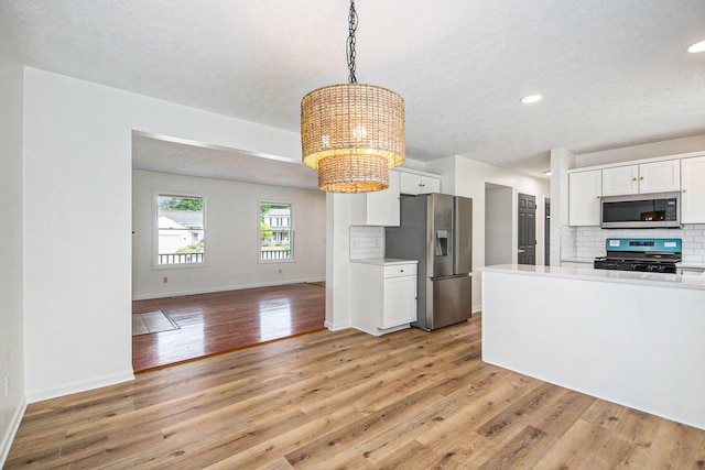 1882 Whistle Stop Dr SE, Grand Rapids, MI 49508 - kitchen with appliances with stainless steel finishes, a chandelier, tasteful backsplash, light wood-type flooring, and recessed lighting