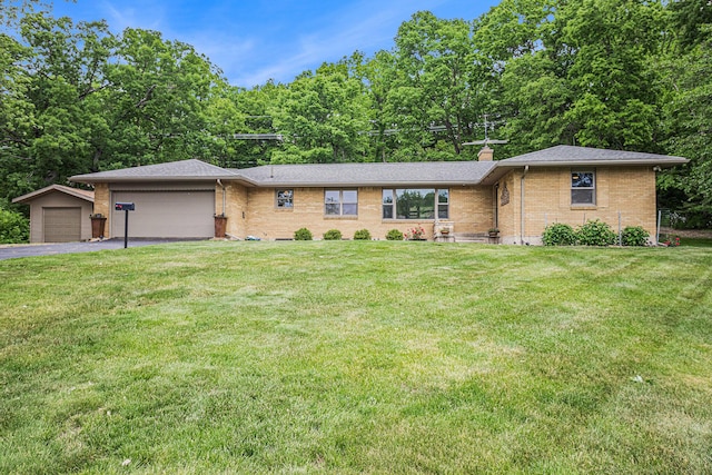6667 W River Rd NE, Belmont, MI 49306 - view of front facade with brick siding, an attached garage, asphalt driveway, and a front lawn