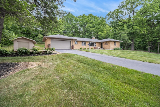 6667 W River Rd NE, Belmont, MI 49306 - single story home featuring brick siding, a detached garage, a front yard, and a chimney