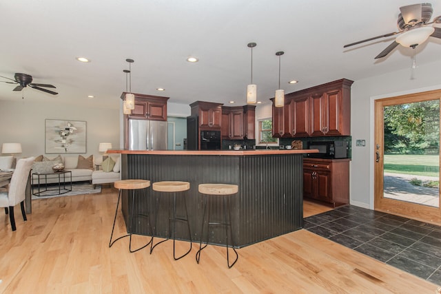 7532 Dell Rd, Saline, MI 48176 - kitchen featuring black appliances, ceiling fan, open floor plan, recessed lighting, and a center island