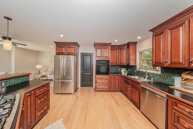 7532 Dell Rd, Saline, MI 48176 - kitchen featuring stainless steel appliances, dark countertops, light wood-style floors, backsplash, and a ceiling fan
