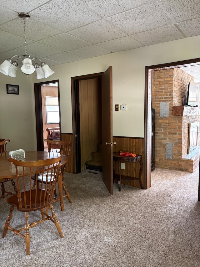 22347 5 Mile Rd, Morley, MI 49336 - carpeted dining area featuring wainscoting, wood walls, a chandelier, and a drop ceiling