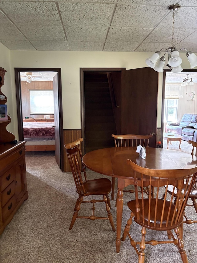 22347 5 Mile Rd, Morley, MI 49336 - carpeted dining area with wainscoting, a chandelier, a drop ceiling, and wood walls
