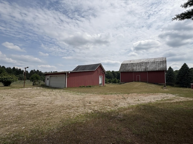22347 5 Mile Rd, Morley, MI 49336 - view of green lawn featuring an outdoor structure, a barn, and a garage