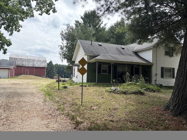 22347 5 Mile Rd, Morley, MI 49336 - rear view of property featuring dirt driveway, an outdoor structure, and roof with shingles
